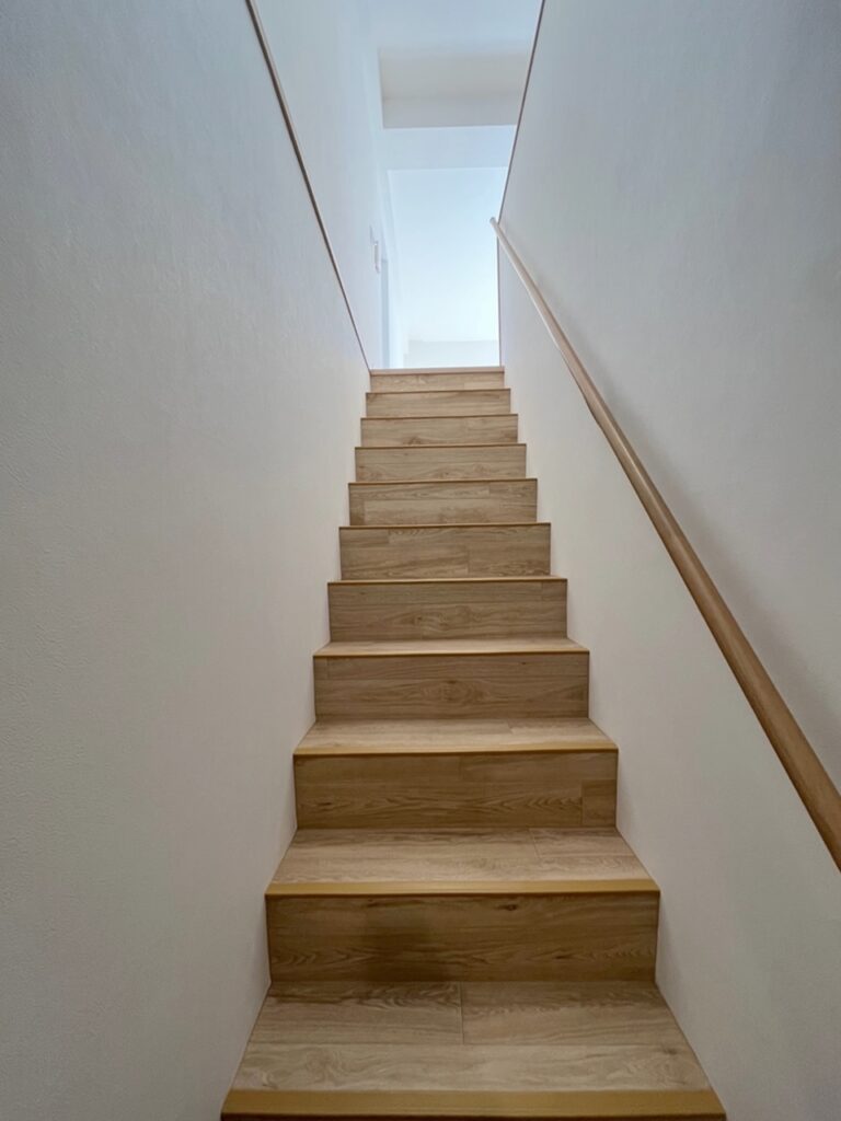 玄関から階段を上る際の様子。ホワイトカラーで一新しました。